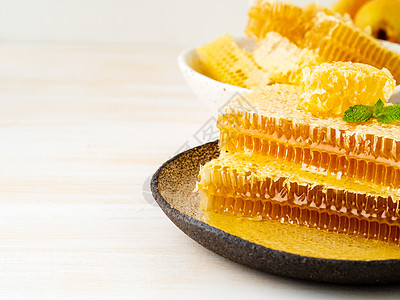 蜂蜜中的蜂蜜 闭合式 棕陶瓷板 木制白锈桌 复制空间美食陶瓷水果液体药品甜点草本植物金子营养蜜蜂图片