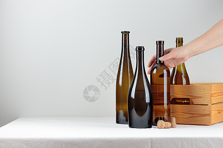 桌上盒子里的绿色葡萄酒瓶木头酒杯红色液体庆典产品反射啤酒软木藤蔓图片