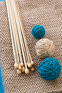 三个多彩球和木制针头 都躺在米格编织的丝袜上情绪织物针织礼物木头装饰品图片