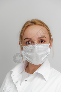 浅色背景下一位戴着医用面具的年轻金发女子的特写 病毒防护 冠状病毒 covid19 大流行病的概念 隔离 呆在家里微生物药品女孩图片