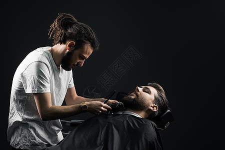 在理发店刮胡子 长着脚镣的理发师修剪英俊胡子的男人大男子男性胡须潮人剃须店铺客户理发顾客黑色图片
