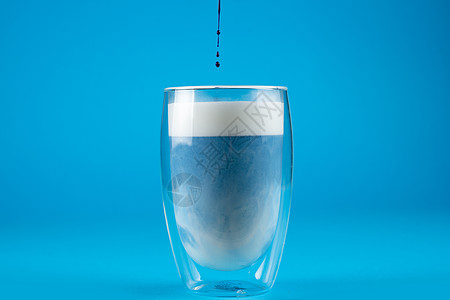 用双玻璃杯把蓝色的 anchan火柴加在双玻璃杯里玻璃泡沫抹茶牛奶酒精奶昔白色饮料拿铁图片