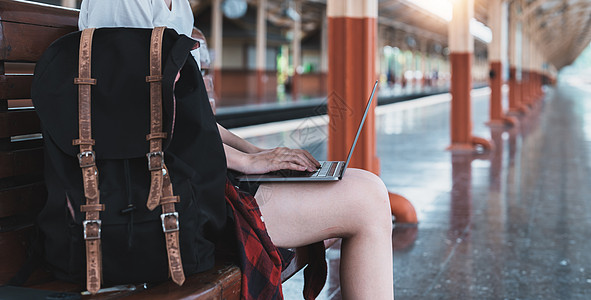 年轻亚洲人自由职业者在火车站工作前旅行的图像 暑期工作和旅行概念背景图片