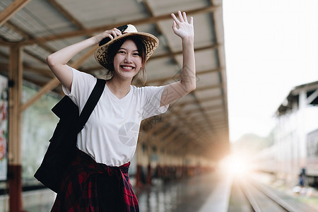 寻找朋友计划在火车站旅行的年轻旅行者妇女 夏天和旅行生活方式概念眼镜成人帽子技术机车手机女士车皮铁路车辆图片