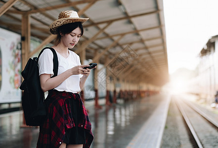 寻找朋友计划在火车站旅行的年轻旅行者妇女 夏天和旅行生活方式概念窗户电话帽子乘客游客运动女孩成人机车商业图片