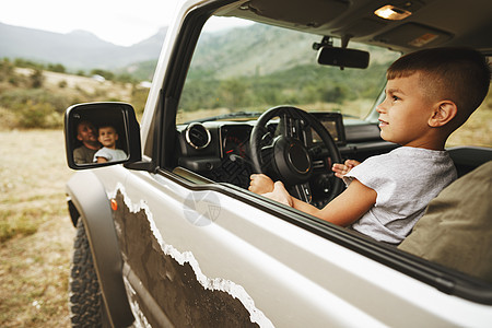 父亲教小儿子在路上开车旅行童年孩子身份汽车教学喜悦微笑享受爸爸乐趣图片