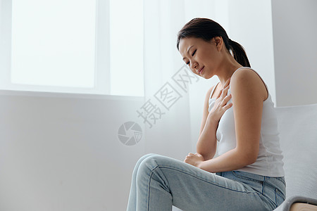 心脏病发作 因疼痛而受苦 晒黑的美丽的亚洲年轻女性在家中室内客厅哭泣时手握胸心 伤势严重 健康疾病概念很差图片