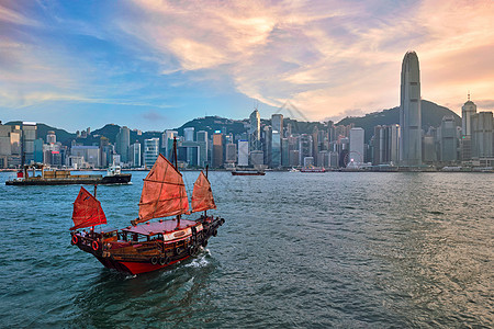 香港维多利亚港湾的垃圾船天际建筑学天空地标商业摩天大楼旅行日落景观港口图片
