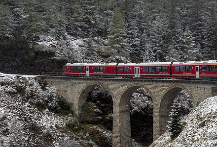 山上一辆红色列车穿越空中的景象图片