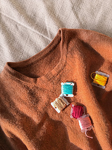 返工地表最顶端的羊毛毛毛衣和彩色刺绣线圈 重塑旧衣服 DIY 手工手工艺品背景