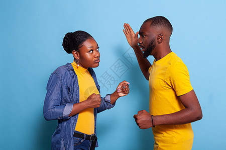 沮丧的男子举手对着女朋友和争吵图片