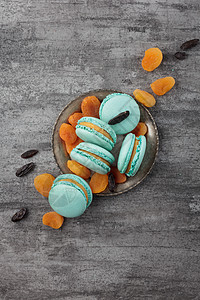 灰色混凝土背景的蓝马卡龙咖啡糖果甜点咖啡店面包蓝色糕点盘子食物图片