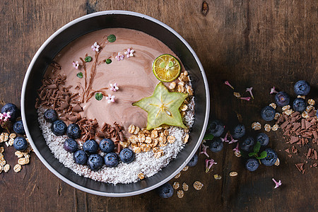 巧克力酸奶 有蓝莓 花粉 椰子 石灰和木质深浅的卡兰波拉 带花的绘画分支 顶部视图 空间牛奶燕麦种子奶油玻璃乡村活力坚果薄片玉米图片