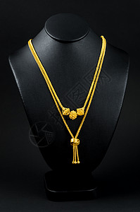 颈项展台和金项链 在黑色背景上金链财经奢华颈部衣领宝石金色对象金属支架图片