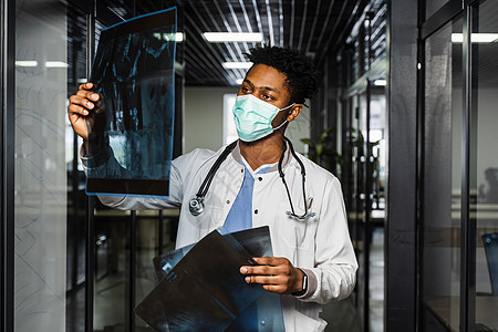 非洲医生在诊所检查X光片 戴医疗面具的黑人学生正在研究和看Ct扫描 校对 Soup快乐男人办公室x射线学习顾问外科工作工人全科图片