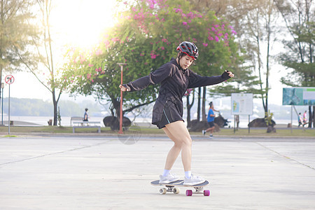 在美丽的夏日 亚洲女性在户外溜冰 早上 快乐的年轻女性在公园玩冲浪板 体育活动生活方式概念闲暇极限爱好街道女孩滚筒运动滑冰溜冰者图片