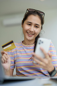 在线购物和互联网支付 美丽的亚洲女性肖像正在使用信用卡和手机在线购物或在数字世界中办事网络幸福金融商业卡片网上购物女士信用技术互图片
