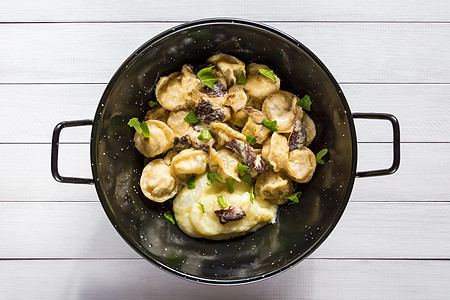 黑碗里有俄式食物蛋浆 配蘑菇酱的肉卷子和土豆泥图片