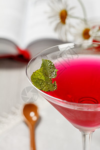 杯子里的樱桃果冻 在玻璃封顶薄荷树叶 用开放书的背景背景图片