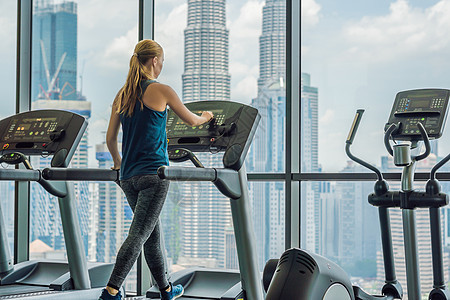 运动 健身 生活方式 技术和人的概念大城市背景下在健身房跑步机上锻炼的女性身体成人赛跑者女孩播客行动耳机火车喜悦工具图片