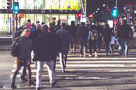 夜间跨越街口的人群图片