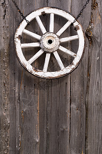 挂在谷仓墙上的旧木制车轮圆圈古董车皮教练日志先锋乡村农业轮缘金属图片