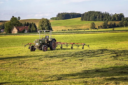 拖拉机和干草台车为耕种准备干草收成 农业和农艺概念 选择性重点车辆场地蓝色农村土地机器草原牧场饲料植物图片