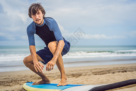 冲浪板图男子冲浪者在冲浪前在海滩上热身 冲浪男子穿着潜水服 在海上带着冲浪板木板乐趣男人微笑男生套装爱好成人太阳墙纸背景