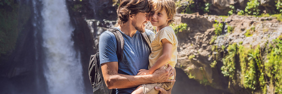 父亲和儿子在瀑布背景的旅游者 与孩子一起旅行的概念 如何对待儿童友好的地方图片