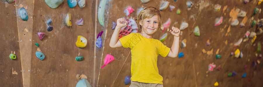 小男孩穿特别靴子爬岩墙 室内银行 长期的FormAT登山者操场成人运动装女性运动挑战风险绳索安全图片
