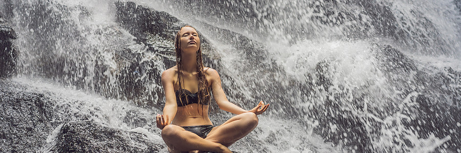 瑜伽banner坐在热带瀑布岩石上的月莲位置的年轻女子 坐落在热带瀑布BANNER LONGFORMAT公园瑜伽平衡男性女性生活运动自由冥想女士背景