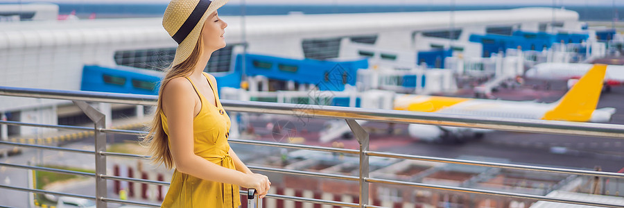 美丽的年轻女子穿黄色洋装和黄皮箱旅行者正在等待班机Long ForMAT的班机AnnER女孩游客休息室假期手提箱航班金发航空公司图片