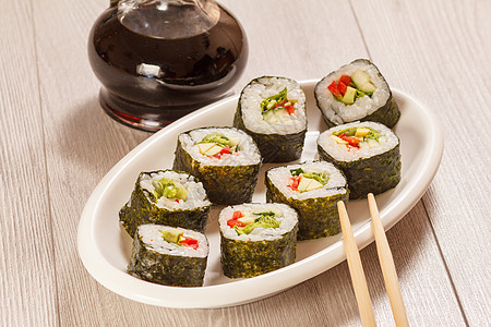 寿司卷 大米 蔬菜和海鲜盘上加一瓶酱油黄瓜筷子食物海藻海苔盘子红色白色黑色寿司图片