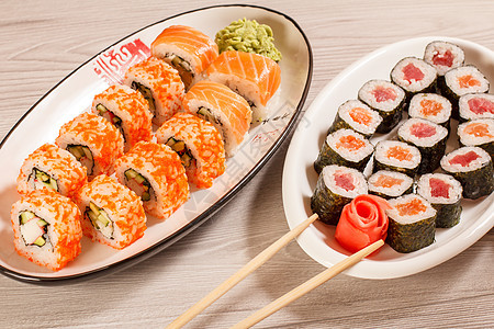 配有大米 蔬菜和海鲜的寿司卷 用木棍制成板食物黄瓜白色红色海苔美食盘子海藻黑色寿司图片