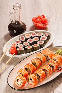 寿司卷 大米 蔬菜和海鲜盘上加一瓶酱油大豆红色黑色美食瓶子海苔寿司海藻白色盘子图片