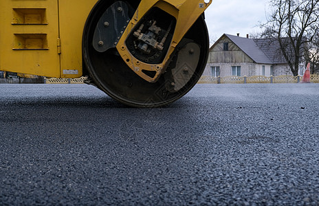在新的道路建筑工地施工时 近距离观察路面滚轮滚筒工作城市沥青机械柏油街道工程车道压实机图片