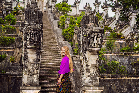 美丽的寺三石梯背景下的年轻女游客 与台阶的夏天风景到寺庙 Paduraksa 门户标志着巴厘岛中间圣地的入口脚步历史建筑遗产女士图片