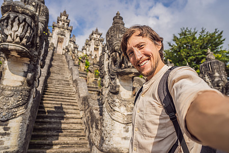 美丽的寺三座石梯背景下的年轻男子游客 与台阶的夏天风景到寺庙 Paduraksa 门户标志着巴厘岛中间圣地的入口图片