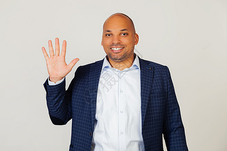成功的年轻非洲裔美国商务人士的画像 用五号手指展示 微笑 自信和快乐 男人露出五个手指 5 号 站在灰色的背景上图片