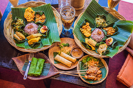 Nasi lemak Nasi campur 印度尼西亚巴厘岛米饭配土豆油条 沙爹百合 炸豆腐 辣煮鸡蛋和花生午餐街道烹饪油炸课图片