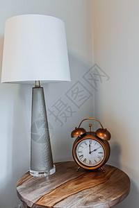 位于 Bedside 表格上的提醒时钟和读取灯房间床头台灯闹钟就寝时间风格小时手表卧室图片