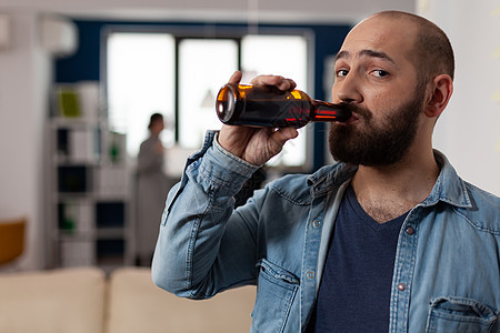 咖啡家男子的肖像 下班后喝酒喝一瓶啤酒图片