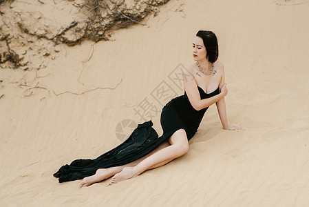 穿着黑色长裙的女孩 在沙沙沙漠天空白色裙子头发蓝色多样性背景沙漠化妆品跑步图片