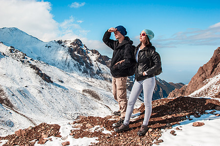 一男一女站在山峡的雪坡边上图片