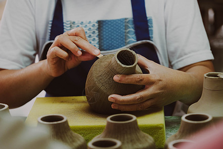 在陶艺作坊中 一位女士的手在粘土花瓶上制作图案的特写镜头 制作陶瓷花瓶的过程 手工艺品和小型企业的概念陶器工匠教学工具车轮手指学图片
