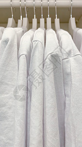 衣柜里挂着白汗衫架子壁橱展示销售衬衫零售洗衣店店铺织物毛衣图片