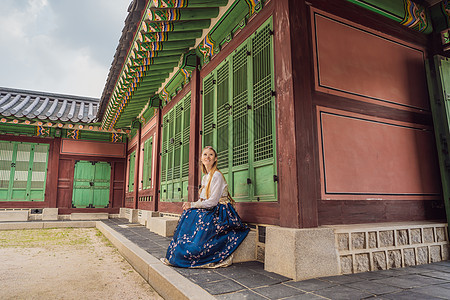 在韩国宫殿穿着韩服的年轻白人女游客 前往韩国的概念 韩国民族服装 游客娱乐试穿韩国民族服饰旅游裙子城市国家女孩时尚地标女士建筑学图片