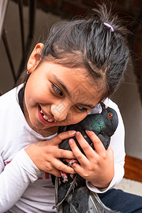 小笑脸女孩抱着宠物 一只小鸽子背景图片