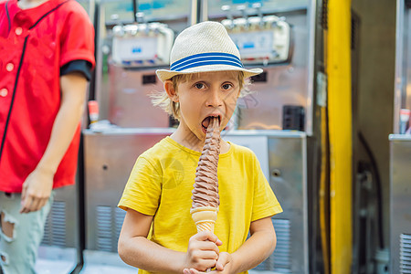 吃 32 厘米冰淇淋的小旅游男孩 1 英尺长的冰淇淋 长冰淇淋是韩国的热门旅游景点 前往韩国的概念 带着孩子旅行的概念甜点帽子男图片