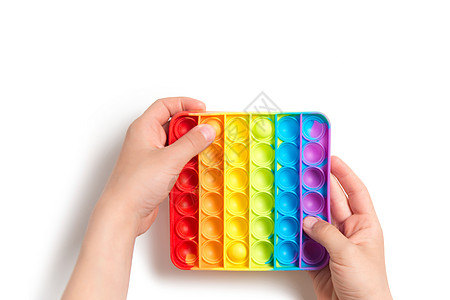 一个儿童推感应器在白色背景背景中被孤立彩虹孩子孩子们技巧正方形动作手指玩具压力流行图片